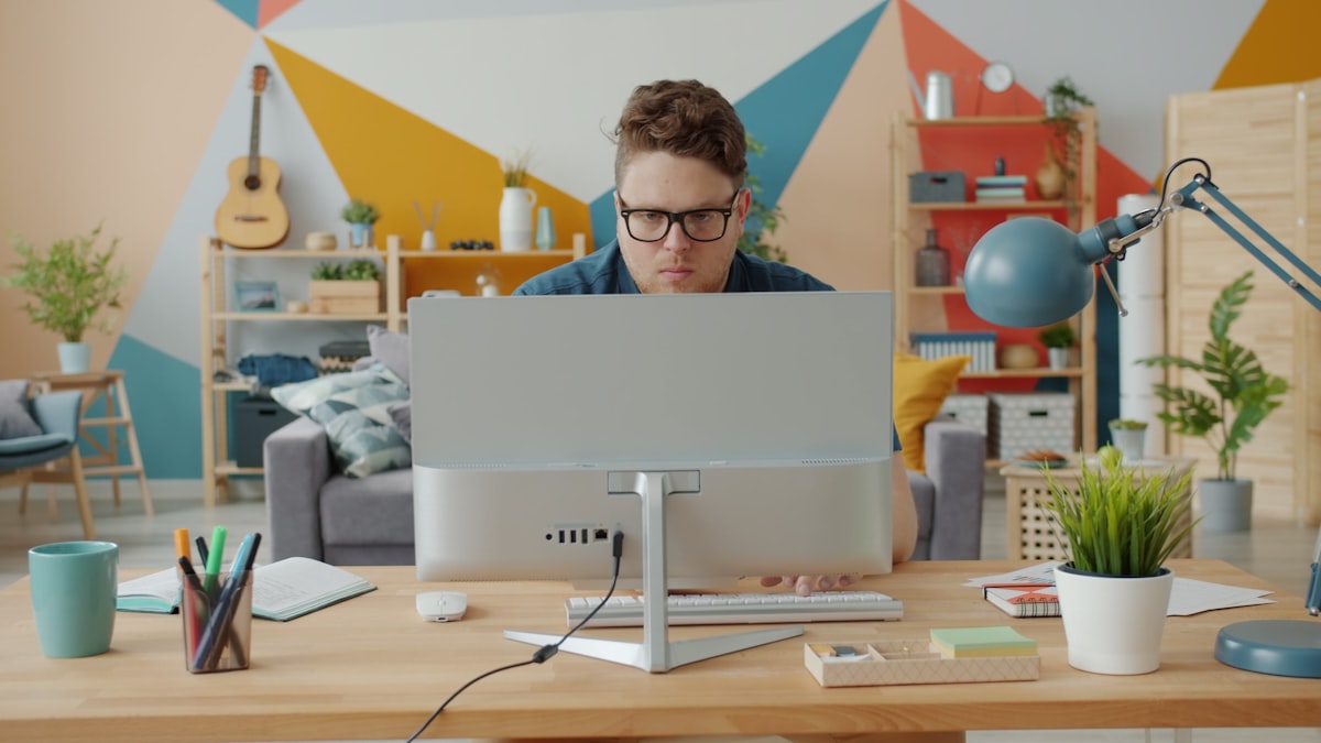Creative professional using AI tools to produce ad variants at scale from a single workstation