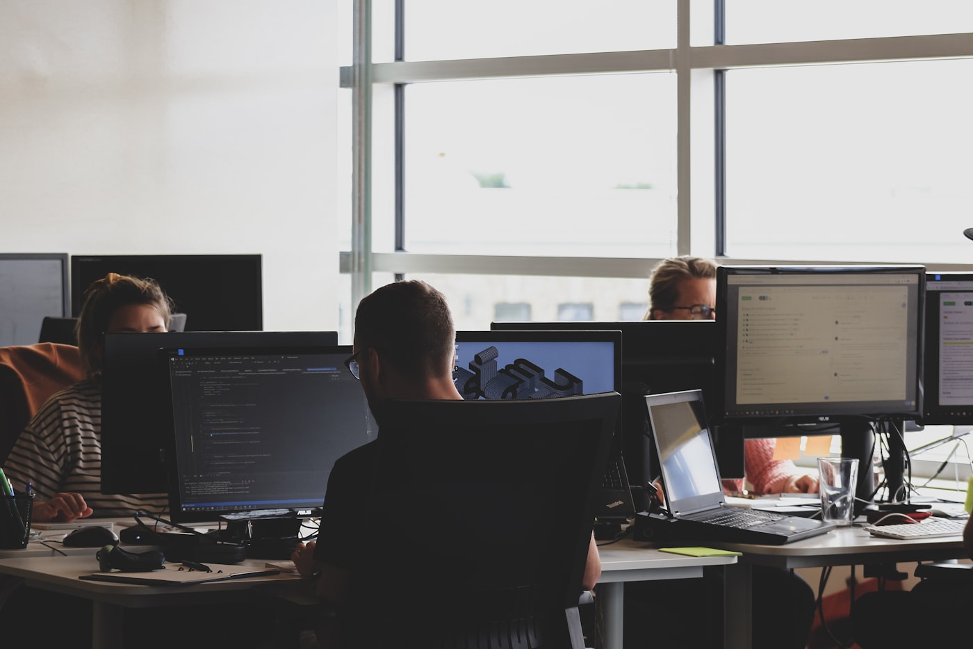 Engineering team collaborating on code review — the human element that harness engineering augments, not replaces