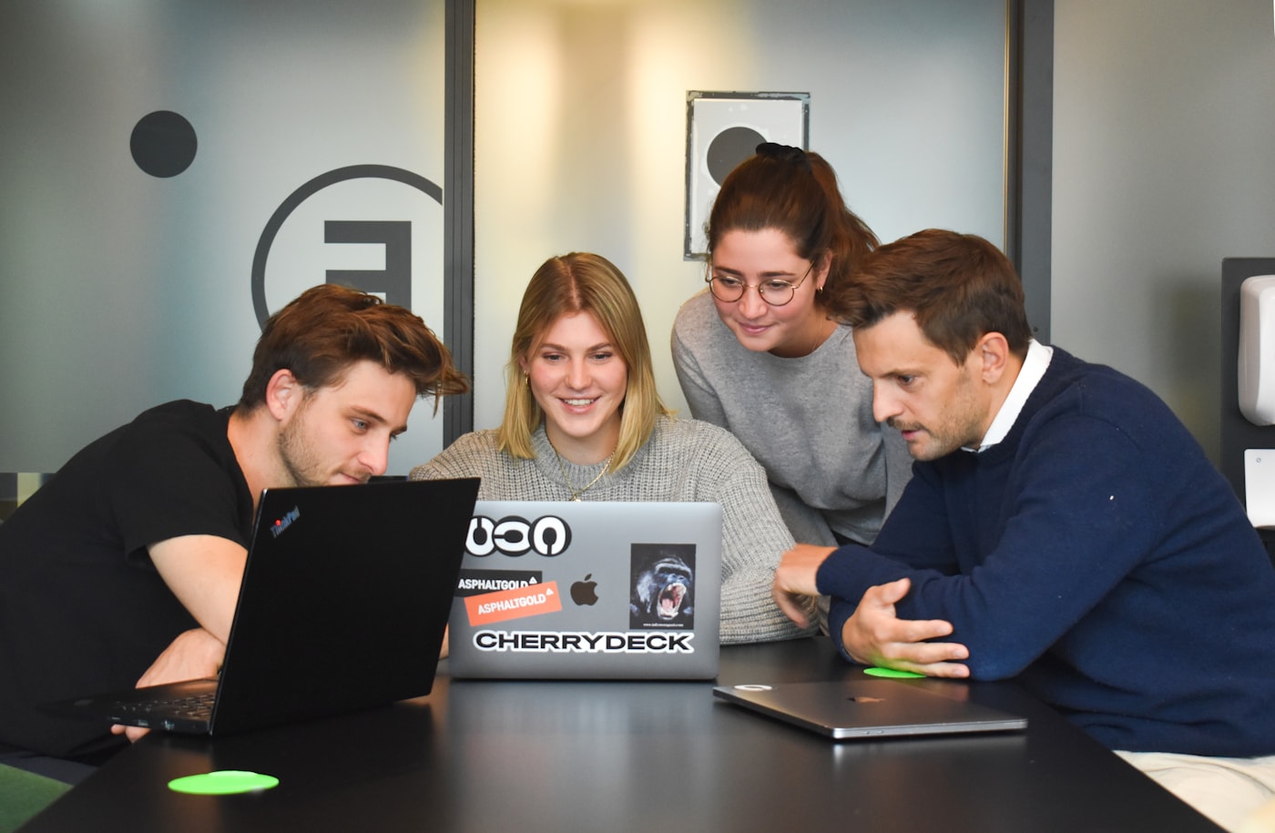 Creative review workspace with laptops and campaign assets on a table